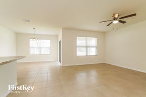 Cape Coral house for rent - A spacious room with a ceiling fan and two windows.