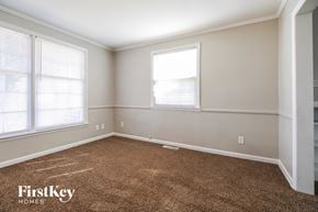 Independence house for rent - a bedroom with a carpeted floor and two windows