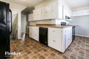 Independence house for rent - a kitchen with white cabinets and a counter top