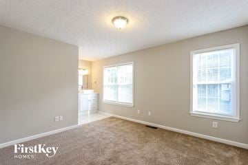 Loganville house for rent - the spacious living room with carpeted flooring and large windows