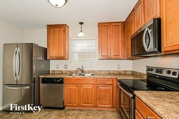 Saint Peters house for rent - A kitchen with wooden cabinets and a stove top oven.
