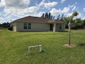 Cape Coral house for rent - a home with a sprinkler in the grass