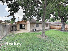 Houston house for rent - the backyard of a house with a yard and trees
