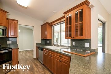 Port Charlotte house for rent - a kitchen with wooden cabinets and a sink and a window