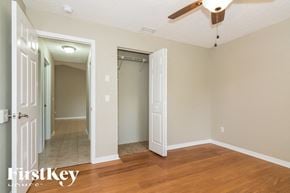 Port Charlotte house for rent - a bedroom with a ceiling fan and a hallway with a closet