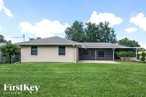 Port Charlotte house for rent - a small house with a grassy yard and a fence