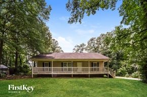 Austell house for rent - a yellow house with a wraparound porch and a yard with trees