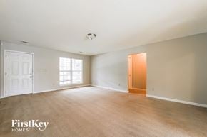 Austell house for rent - an empty living room with a door to a hallway and a window