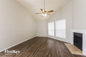 Houston house for rent - a living room with a ceiling fan and a fireplace