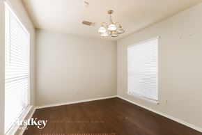 Houston house for rent - a bedroom with wood floors and white walls and a large window