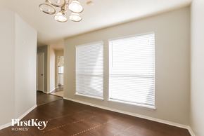 Houston house for rent - a dining room with three windows and a hallway with a door to a house