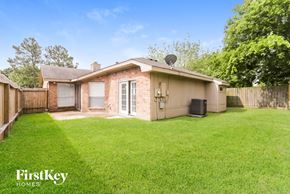 Houston house for rent - a backyard with a small house and a grassy yard