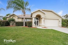 Fort Myers house for rent - A house with a palm tree in front of it.