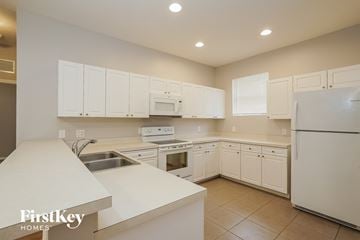 Fort Myers house for rent - A kitchen with white cabinets and appliances.