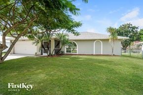 Fort Myers house for rent - A white house with a tree in front of it.