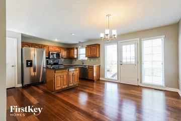 Olathe house for rent - A kitchen with wooden cabinets and a refrigerator.