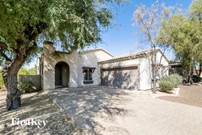 Phoenix house for rent - A house with a driveway and a tree in front of it.