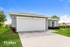 Port St. Lucie house for rent - A modern house with a white garage door is for sale by FirstKey Homes.