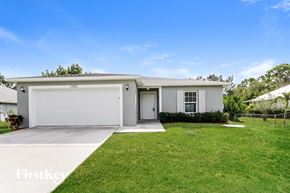 Port St. Lucie house for rent - A white house with a garage is for sale.