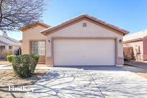 Surprise house for rent - A beige house with a garage door and a tree in the front yard.