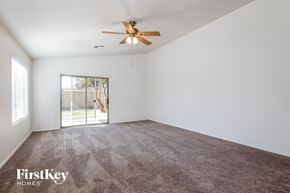 Surprise house for rent - A room with a ceiling fan and a sliding glass door leading outside.