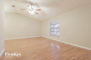 Palm Bay house for rent - A room with a ceiling fan and wooden flooring.