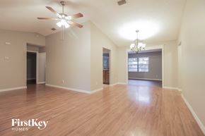 Palm Bay house for rent - A spacious room with wooden flooring and a ceiling fan.