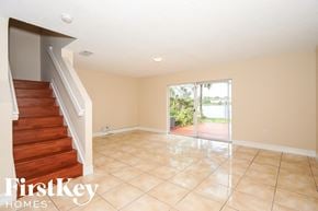 Miami house for rent - A spacious room with a staircase and sliding glass doors leading to a patio.