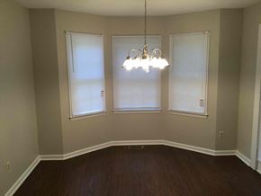 Douglasville house for rent - A room with a wooden floor and a chandelier hanging from the ceiling.