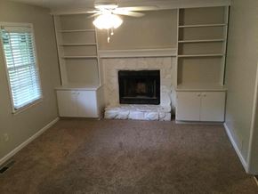 Douglasville house for rent - A living room with a fireplace and built-in shelves.