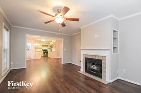 Clemmons house for rent - A spacious living room with a fireplace and a ceiling fan.