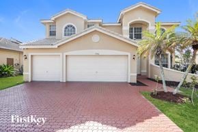 Miramar house for rent - a beige house with a garage door and a palm tree