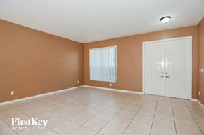 Miramar house for rent - an empty living room with a white tile floor and a white door