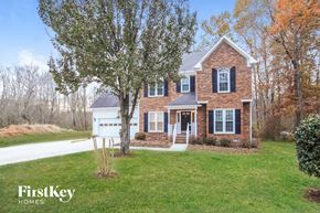 Kernersville house for rent - A brick house with a white door and windows is surrounded by trees.