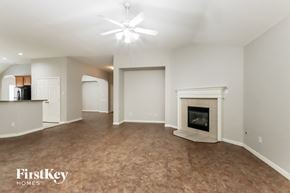 Humble house for rent - A spacious living room with a fireplace and a ceiling fan.
