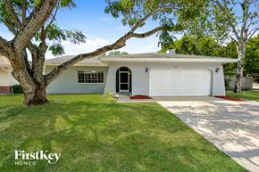 Palm Harbor house for rent - a white house with a lawn and a garage door