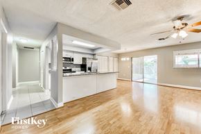 Palm Harbor house for rent - a living room with a kitchen and a ceiling fan