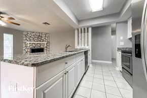 Palm Harbor house for rent - a kitchen with white cabinets and granite counter tops