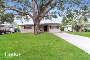 Clearwater house for rent - a home with a large tree in the yard and a driveway