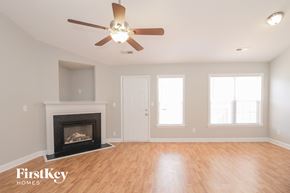 Winston-Salem house for rent - A room with a fireplace and a ceiling fan.