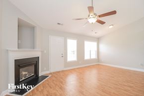 Winston-Salem house for rent - A room with a fireplace and a ceiling fan.