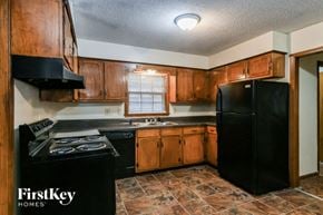 Memphis house for rent - a kitchen with black appliances and wooden cabinets