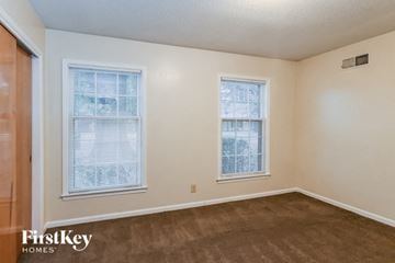 Memphis house for rent - a living room with a carpet and two windows