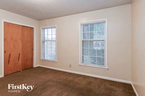 Memphis house for rent - a bedroom with a carpeted floor and a door and two windows