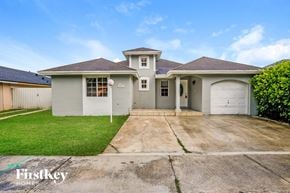Miami house for rent - a white house with a driveway and a garage door