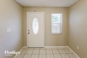 Miami house for rent - the living room has a tile floor and a white door