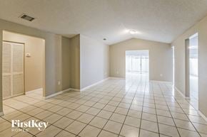 Miami house for rent - a spacious living room with tiled flooring and a door to the patio