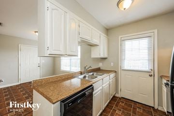San Antonio house for rent - A kitchen with white cabinets and a brown countertop.