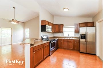 Brandon house for rent - a kitchen with wooden cabinets and stainless steel appliances