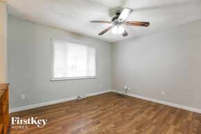 Blue Springs house for rent - A room with a ceiling fan and wooden flooring.